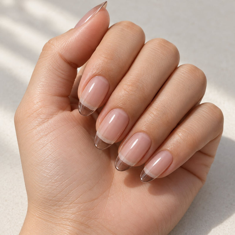 Mano con extensiones de forma almond, en transparente, con acabado brillante.