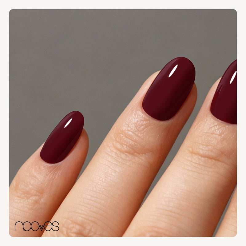 Mano con extensiones de forma oval, en granate oscuro, con acabado brillante.