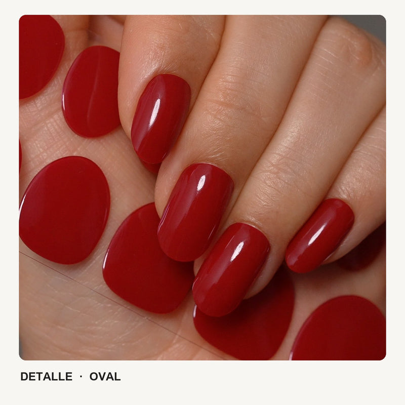 Detalle de uñas de forma oval, en rojo, con acabado brillante.