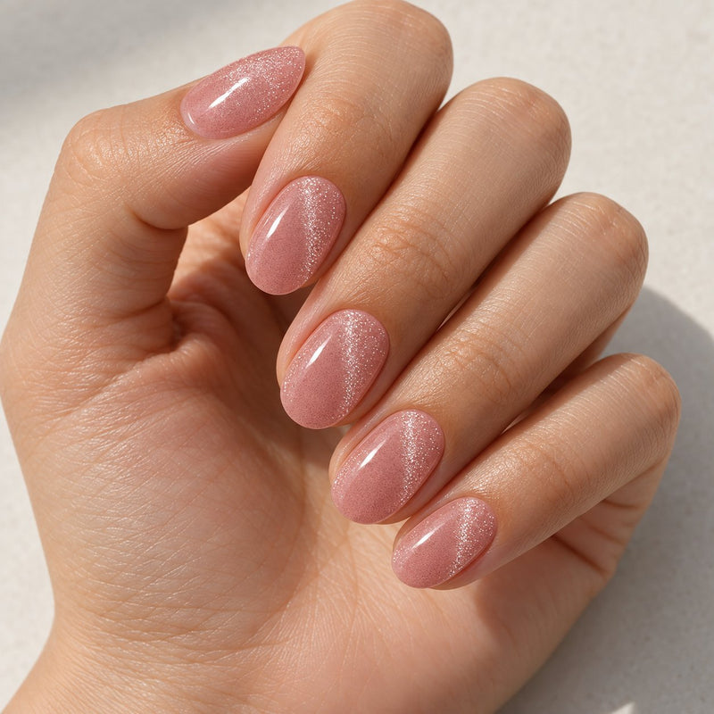 Mano con extensiones de forma oval, en rosa claro con efecto ojo de gato, con acabado brillante.