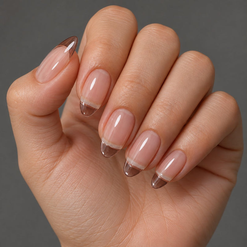 Mano con extensiones de forma almond, en transparente, con acabado brillante.