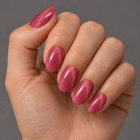 Mano con extensiones de forma oval, en rosa con efecto ojo de gato, con acabado brillante.