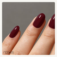 Mano con extensiones de forma oval, en granate oscuro, con acabado brillante.
