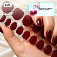 Extensiones de gel NOOVES Cherry Noir, forma oval, mano y tira sobre satén