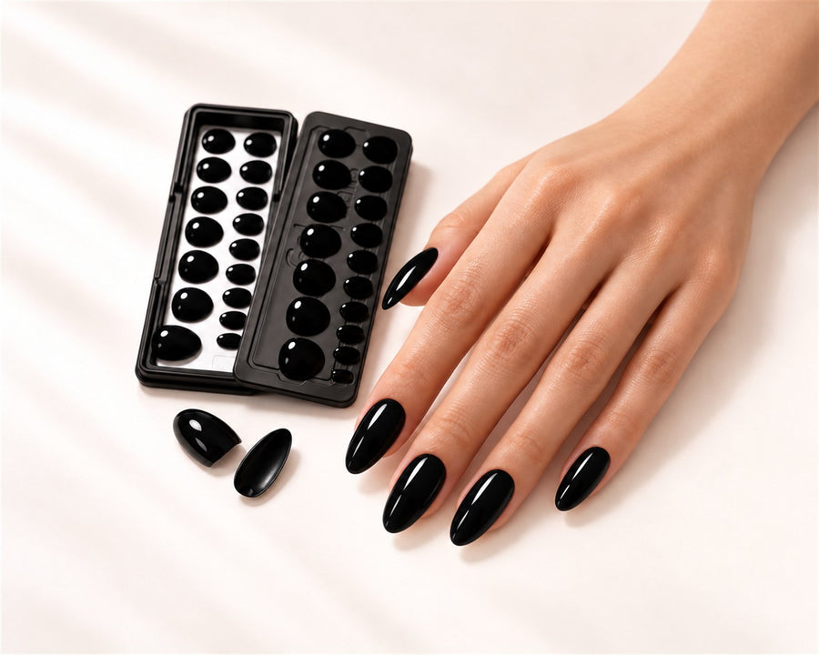 Mano con Extensiones de Gel negras en forma almendra junto a su bandeja
